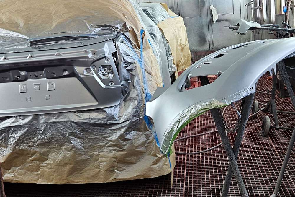 Autolakering af bildele i sprøjtekabine hos Frederikssund Autolakering og Skadecenter.