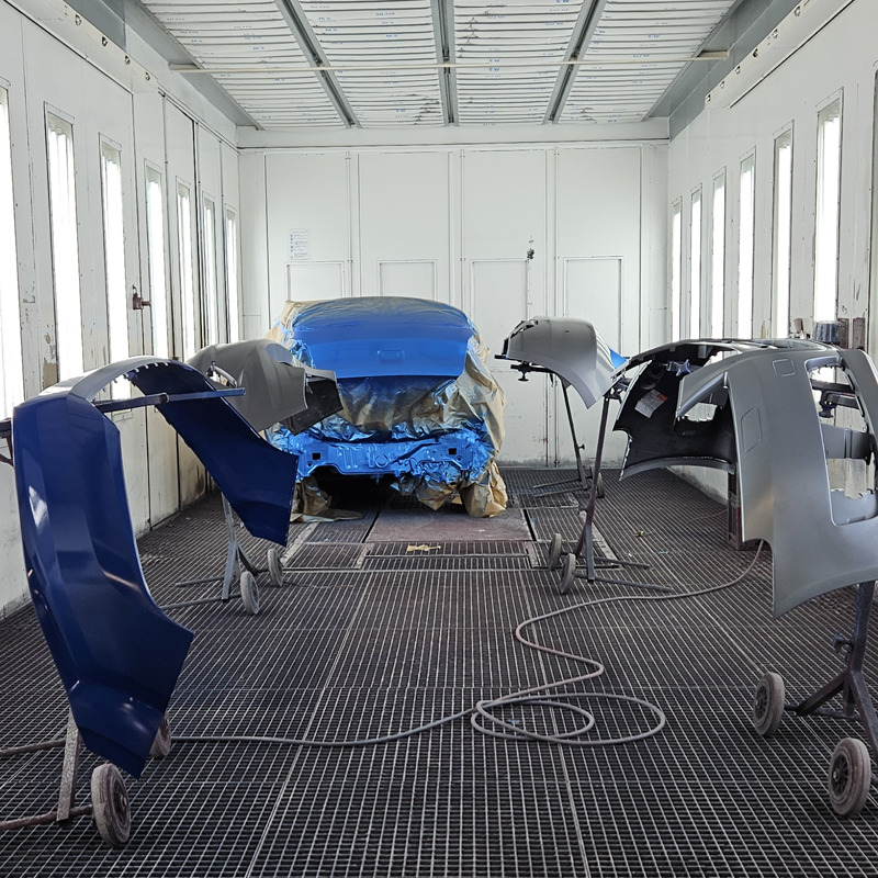 Malerkabine med emner klar til lakering hos Frederikssund Autolakering og Skadecenter. Præcis farveblanding og dokumentation via Workflow. 